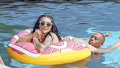 A tattooed girl gets her body on top of a naked body